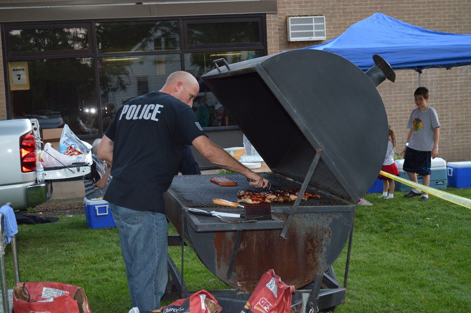 Villa Park Detective Hruby grills up food for community members at a National Night Out event at the Iowa Community Center, Aug. 2.